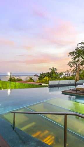 Piscina infinita al atardecer con vistas al mar en una villa en Cruz de Huanacaxtle