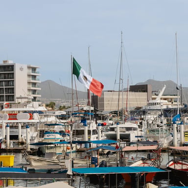 Barcos de pesca y veleros en un puerto deportivo mexicano con la bandera de México ondeando
